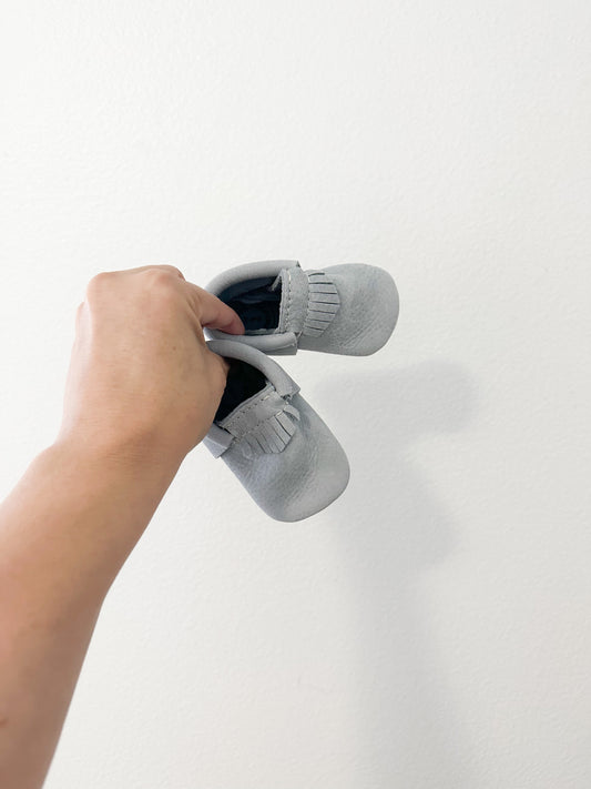 Freshly picked leather moccasin baby shoe in snow on earth || size 3