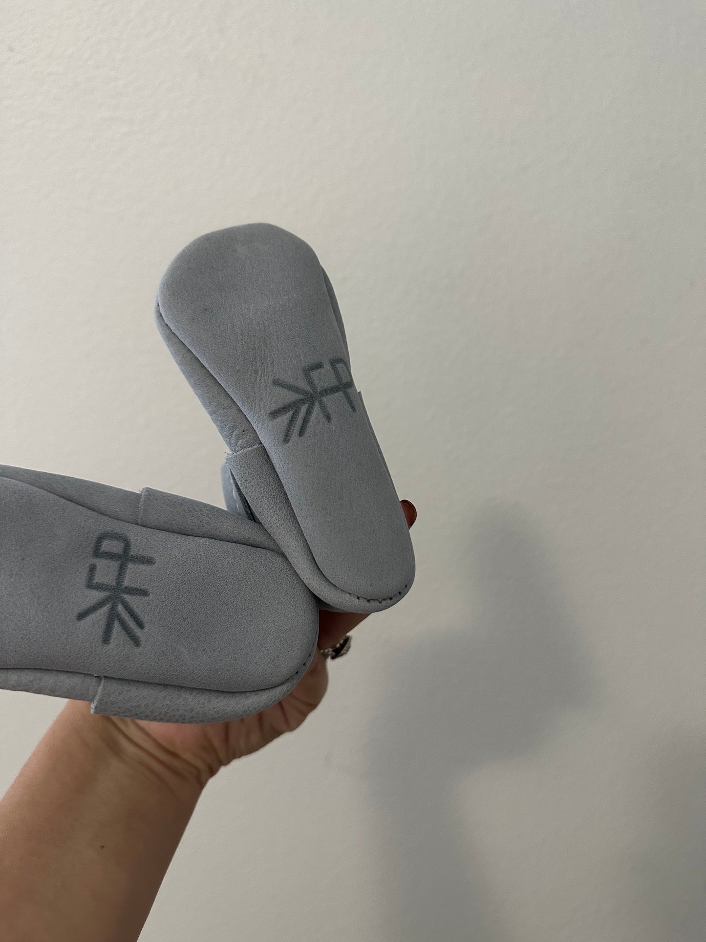 Freshly picked leather moccasin baby shoe in snow on earth || size 3